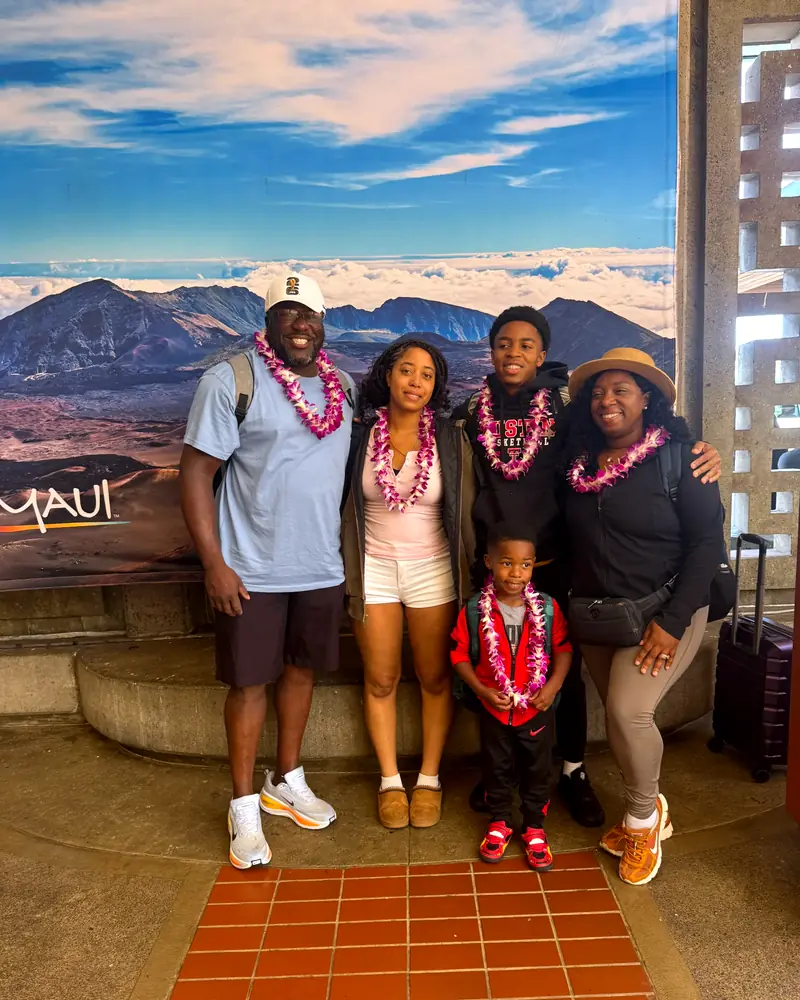 A family of five wearing fresh orchid lei after their greeting at Kahului Airport