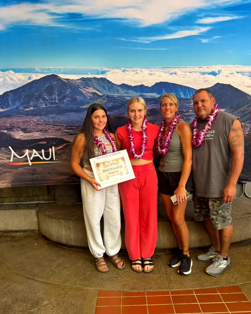 Group of four in orchid lei holding a lei greeting certificate