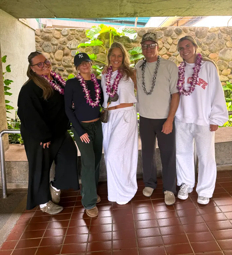 Group of five wearing orchid lei at the airport greeting area