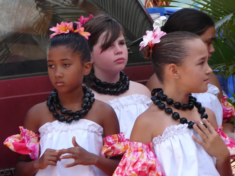 Young hula dancers wearing dark kukui nut lei